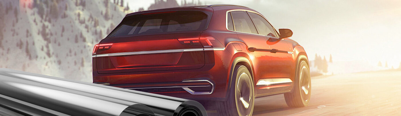 A red SUV driving through snowy mountains, showcasing PAMAGOO ceramic window tint